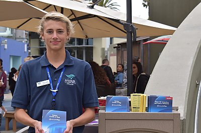 Teenager poses with a visitor guide outside the Aquarium. - thumbnail